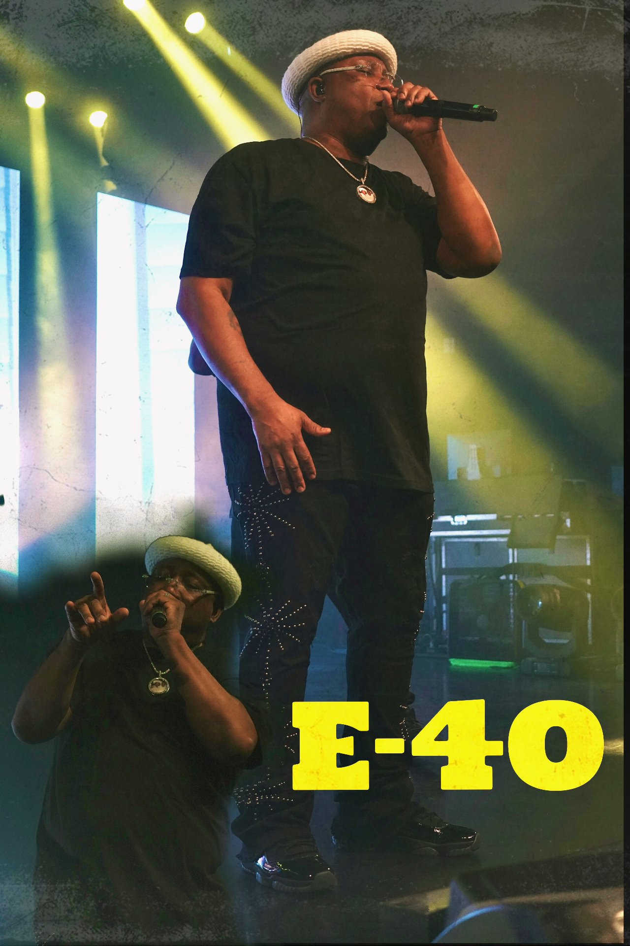 E-40 performing on stage with yellow stage lights